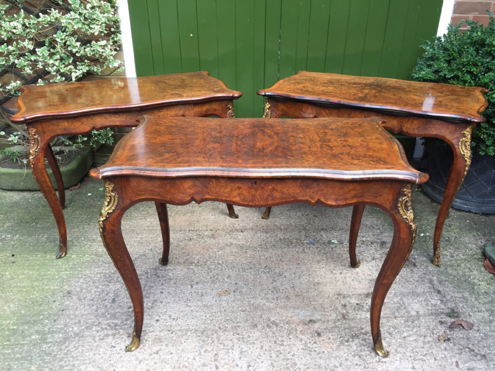 matched midvictorian suite of ormolumounted circassian burrwalnut and figuredwalnut tables comprising of a closelymatched 'pair' of gamingcard tables and an ensuite singledrawer writing table or bureauplat