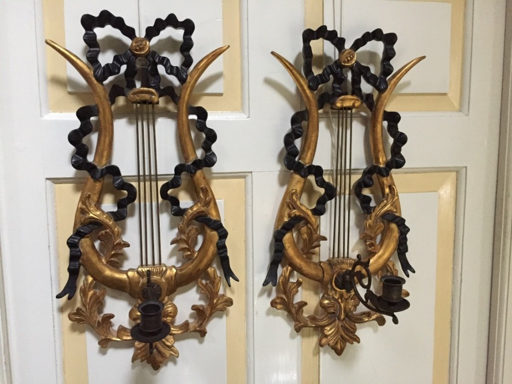 decorative pair of early c20th italian ebonised and gilt lyreform wall appliqus or girandoles with candlearms