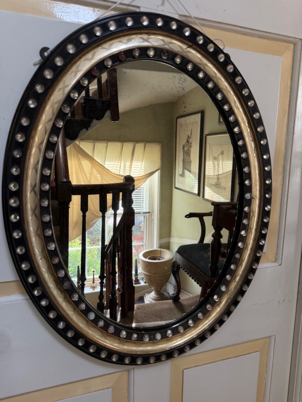 early c19th irish ebonised and parcel silvergilt oval framed mirror with applied glass decoration