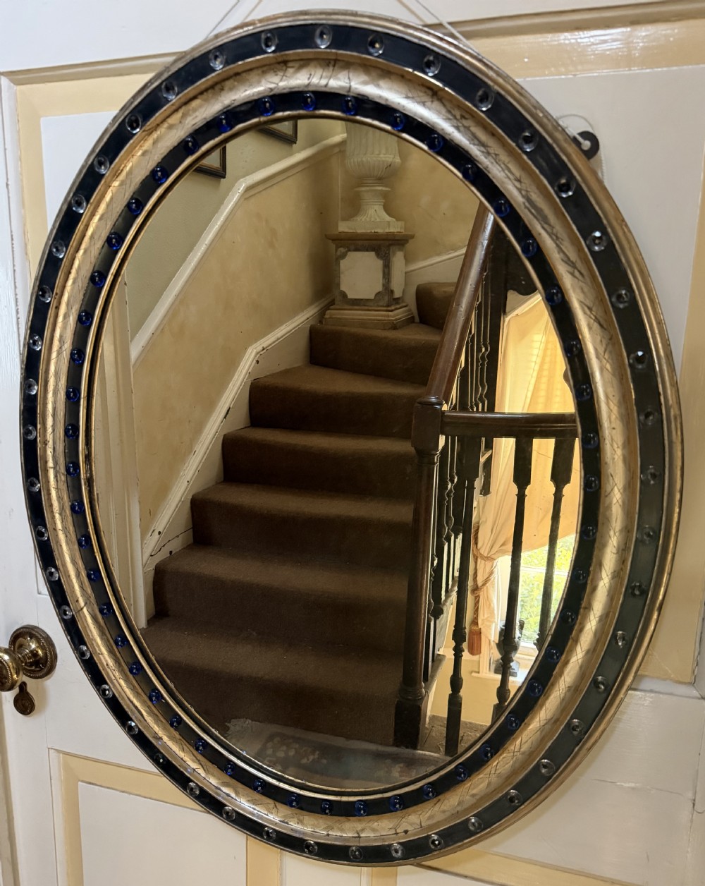scarce larger scale early c19th irish ebonised and silvergilt framed oval mirror with clear facetted glass jewels and colbalt blue glass cabochons